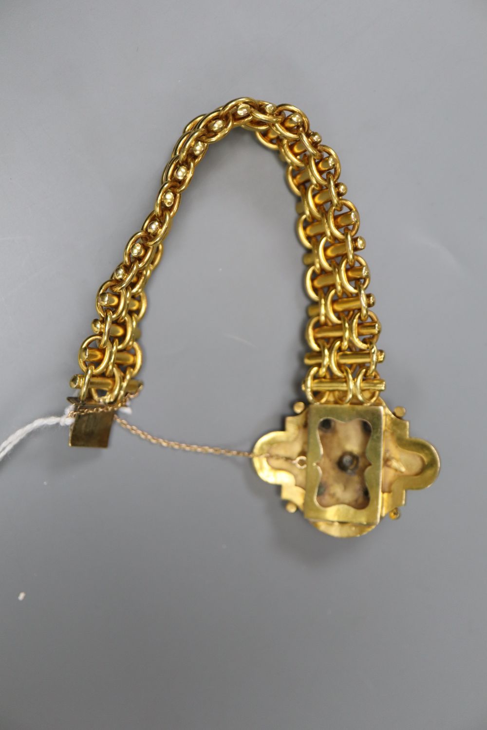 A Victorian yellow metal, emerald and seed pearl set bracelet, with cartouche shaped central motif, approx. 19cm, gross 38.5 grams.